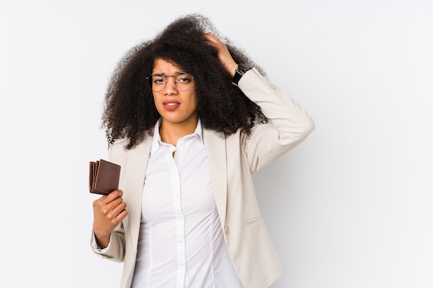 Young afro business woman holding a credit car isolated Young afro business woman holding a credit carbeing shocked