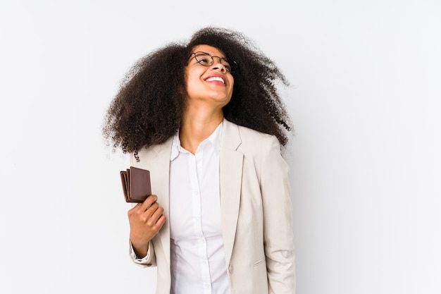 Young afro business woman holding a credit car isolated Young afro business woman holding a credit cardreaming of achieving goals and purposes