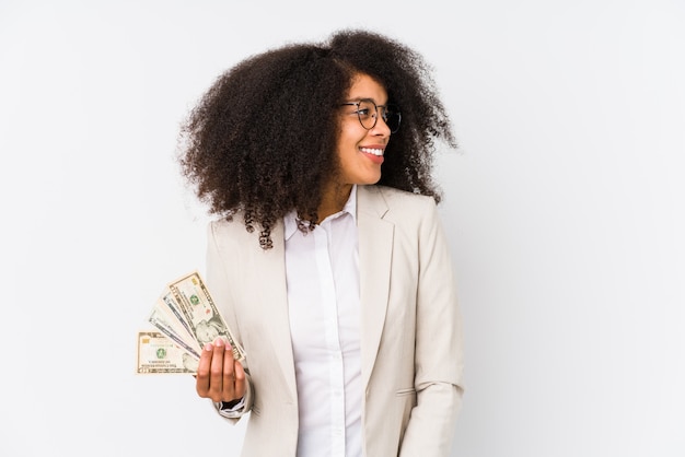 Young afro business woman holding a credit car isolated Young afro business woman holding a credit carlooks aside smiling, cheerful and pleasant.