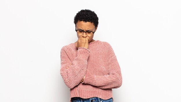 Young afro woman feeling serious, thoughtful and concerned, staring sideways with hand pressed against chin