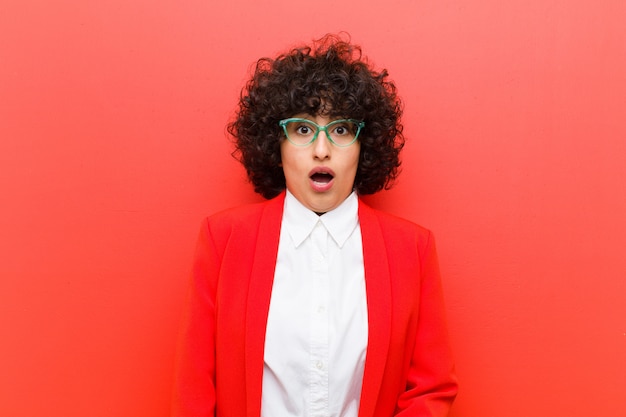 Photo young afro woman feeling terrified and shocked, with mouth wide open in surprise