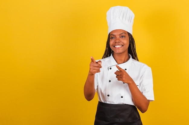 Young AfroBrazilian woman chef pointing at screen choosing you