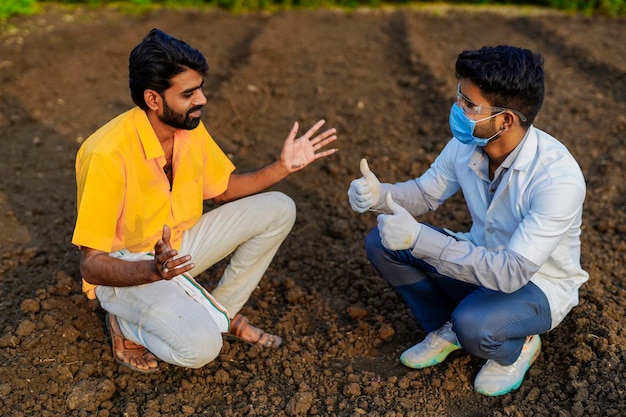 Young agronomist checking soil quality at field