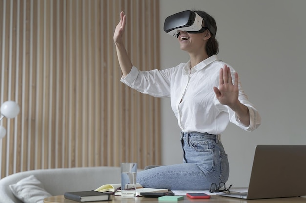 Young amazed businesswoman in virtual reality glasses testing innovative method for business