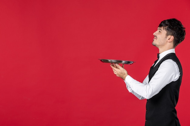 Photo young ambitious man waiter in a uniform