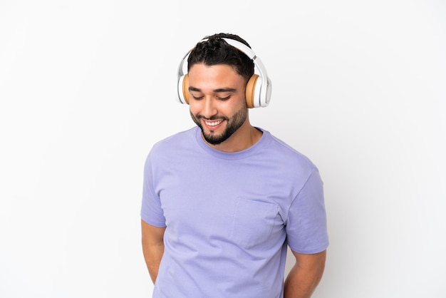 Young arab man isolated on white background listening music