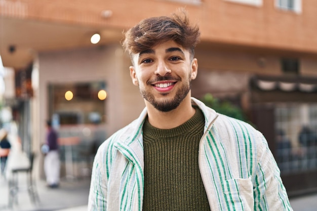 Young arab man smiling confident standing at street