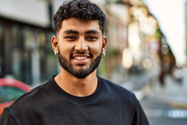 Young arab man smiling confident at street