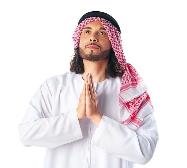 Young arab man in traditional clothing praying on white background