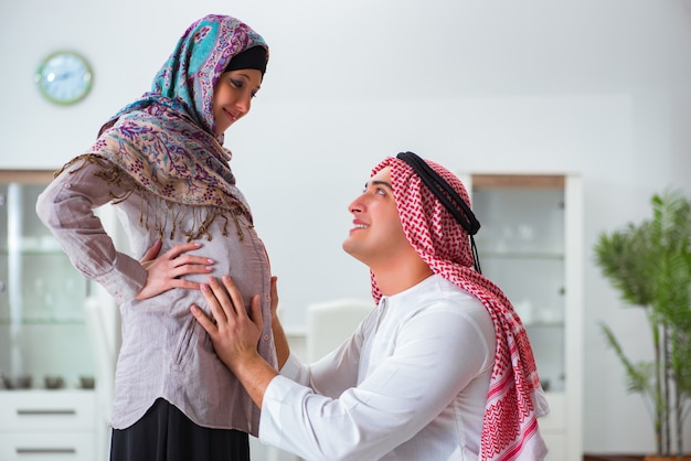 Young arab muslim family with pregnant wife expecting baby