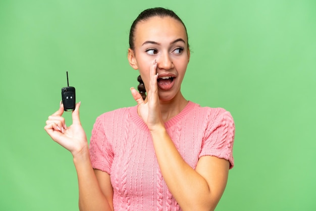 Young Arab woman holding car keys over isolated background whispering something