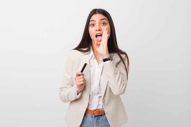 Young arab woman holding a credit card shouting excited front.