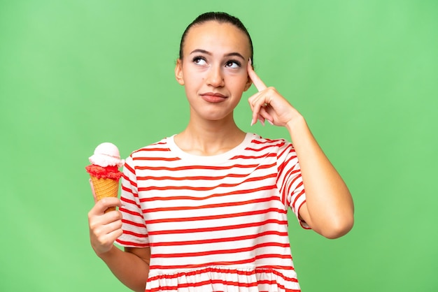 Young Arab woman with a cornet ice cream over isolated background having doubts and thinking