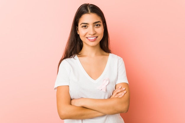 Young arab woman with a pink bow. Concept of fight against cancer.