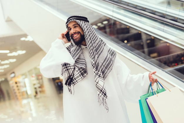 Young Arabian Man Using Cell Phone in Modern Mall.