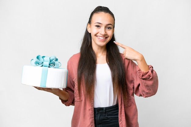 Young Arabian woman holding birthday cake over isolated white background giving a thumbs up gesture