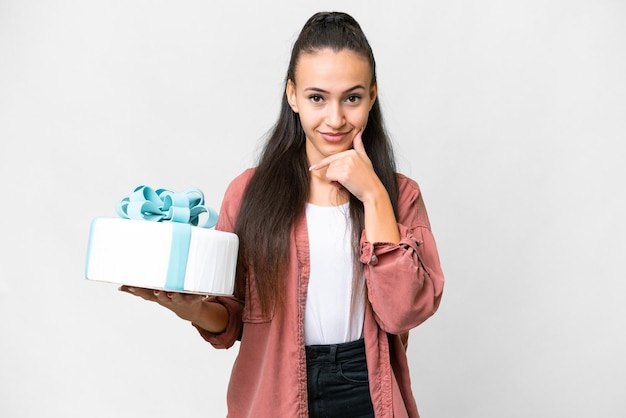 Young Arabian woman holding birthday cake over isolated white background thinking