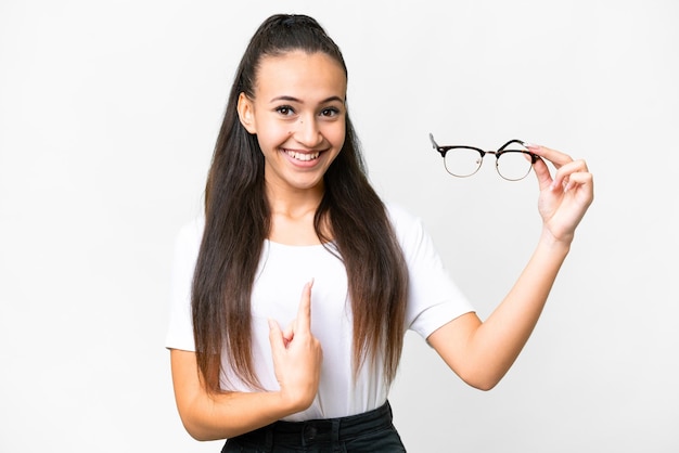 Young Arabian woman holding glasses over isolated white background with surprise facial expression