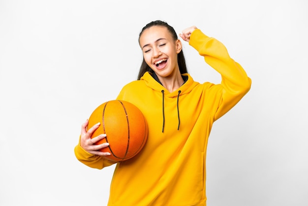 Young Arabian woman playing basketball over isolated white background celebrating a victory