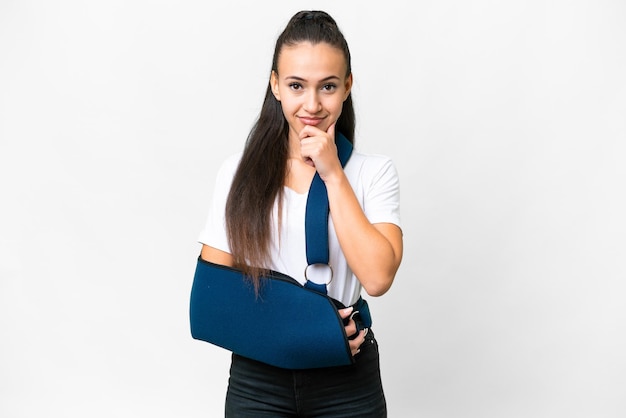 Young Arabian woman with broken arm and wearing a sling over isolated white background thinking