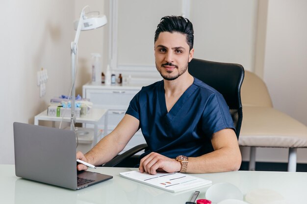 A young arabic or turkish doctor in a blue uniform conducts online counseling