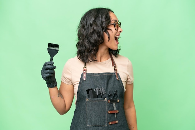 Young argentinian hairdresser woman over isolated background laughing in lateral position