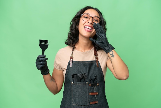 Young argentinian hairdresser woman over isolated background shouting with mouth wide open