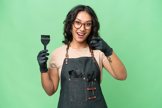 Young argentinian hairdresser woman over isolated background surprised and pointing front