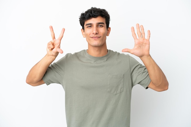 Young Argentinian man isolated on white background counting eight with fingers