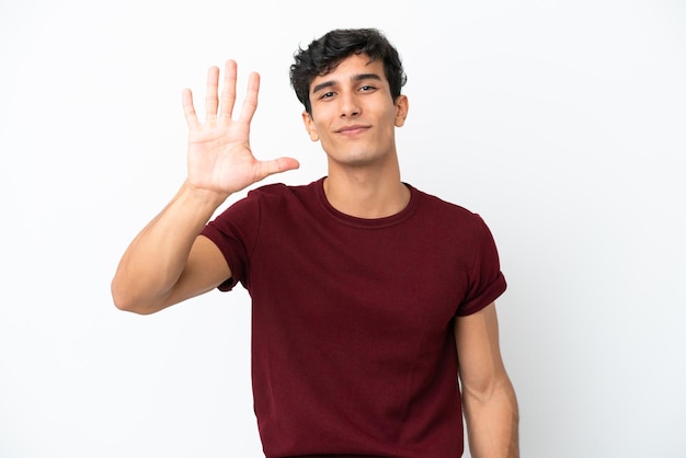 Young Argentinian man isolated on white background counting five with fingers