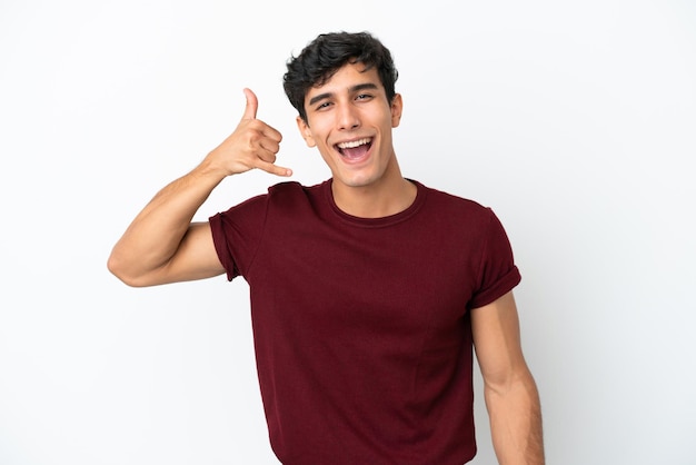 Young Argentinian man isolated on white background making phone gesture. Call me back sign