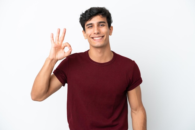 Young Argentinian man isolated on white background showing ok sign with fingers