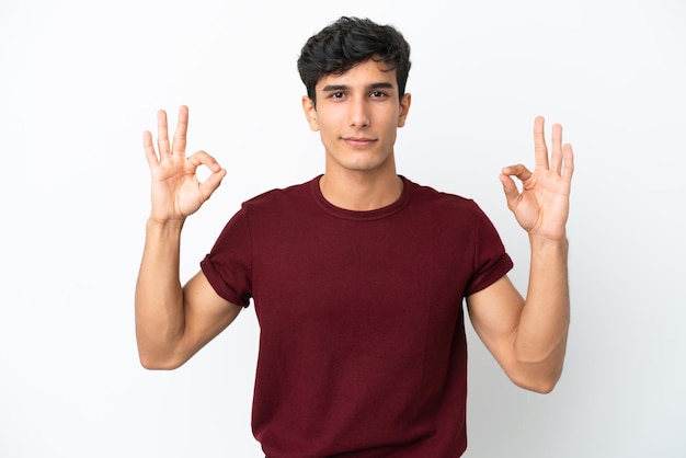 Young Argentinian man isolated on white background in zen pose