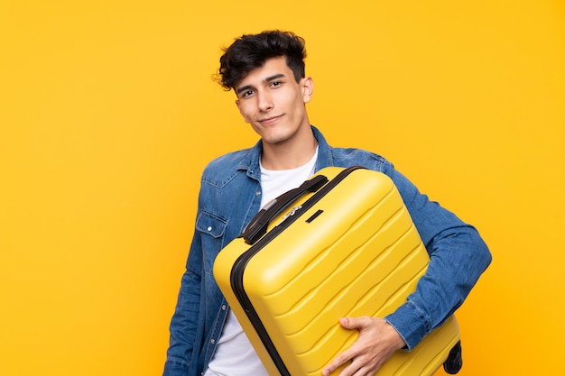 Young Argentinian man in vacation with travel suitcase