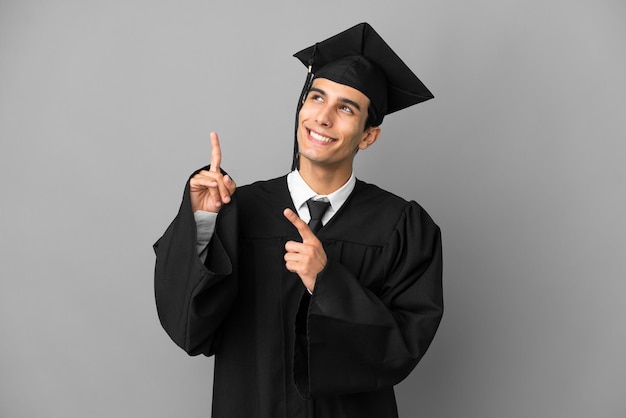 Young Argentinian university graduate isolated on grey background pointing with the index finger a great idea