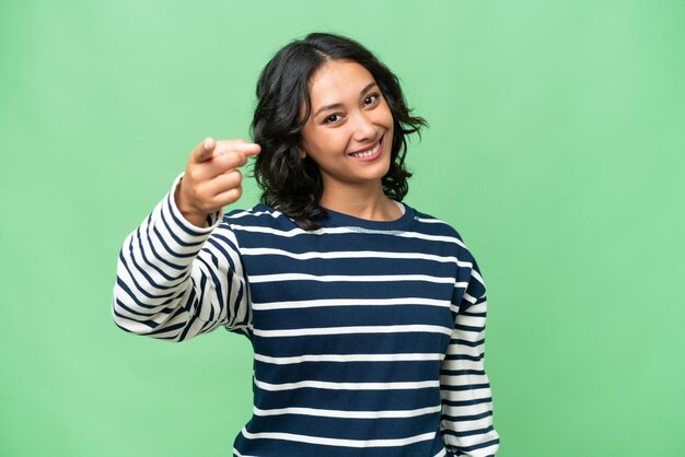 Young Argentinian woman over isolated background points finger at you with a confident expression