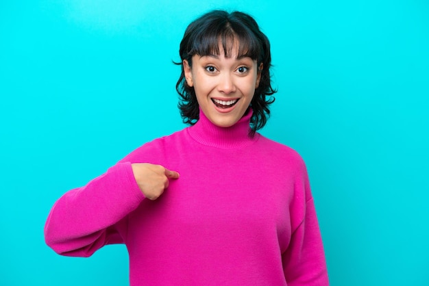 Young Argentinian woman isolated on blue background with surprise facial expression