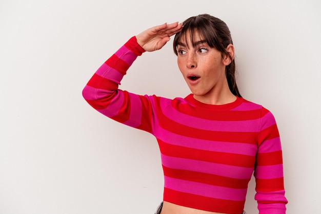 Young Argentinian woman isolated on white background looking far away keeping hand on forehead.