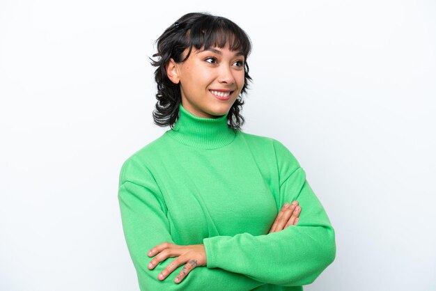 Young Argentinian woman isolated on white background looking up while smiling