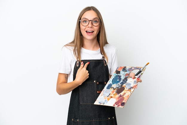 Young artist Lithuanian woman holding a palette isolated on white background with surprise facial expression