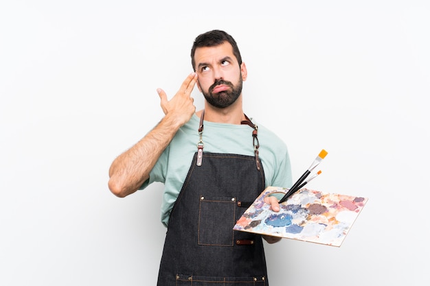 Photo young artist man holding a palette with problems making suicide gesture