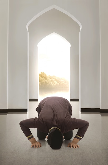 Young asiah muslim man with cap praying