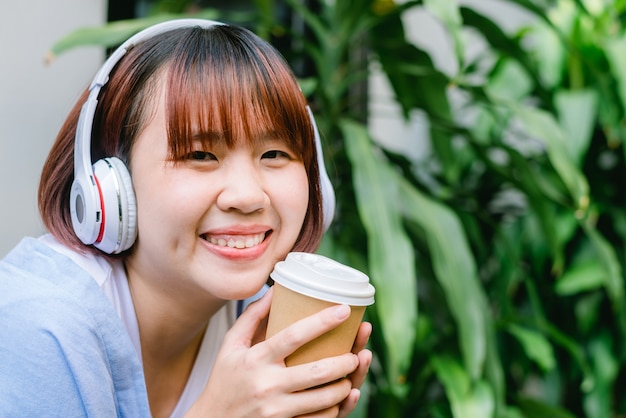 young asian adult woman drinking coffee smiling in cafe.