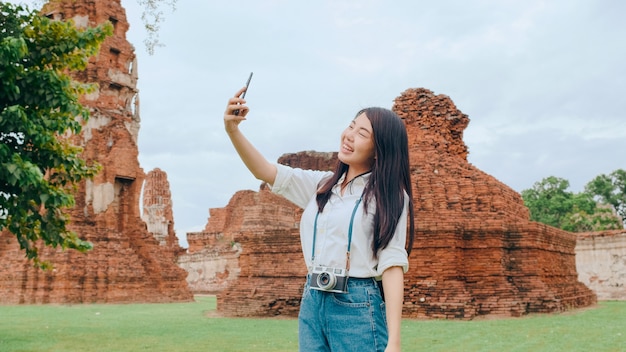 Young Asian backpacker blogger woman takes selfie