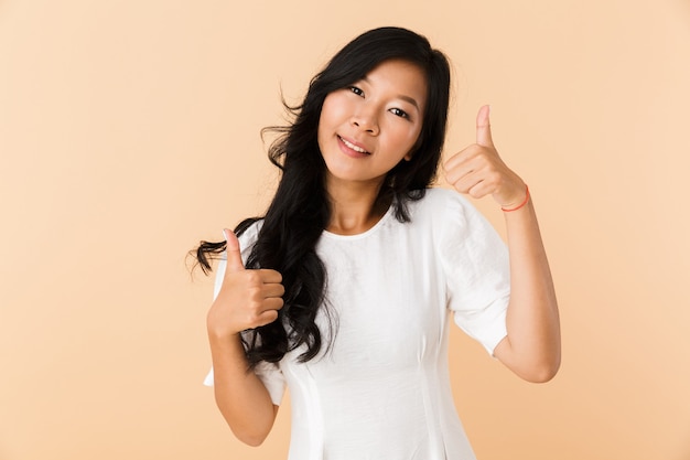 Young asian beautiful attractive woman posing isolated indoors showing thumbs up gesture.