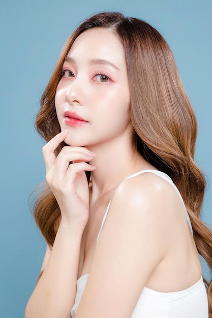 Young Asian beauty woman curly long hair with korean makeup style on face and perfect clean skin on isolated blue background Facial treatment Cosmetology plastic surgery