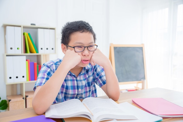 Young asian boy feel tired and sleepy from reading book