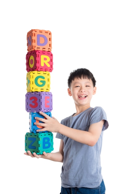 Young asian boy holding alphabet blocks over white background