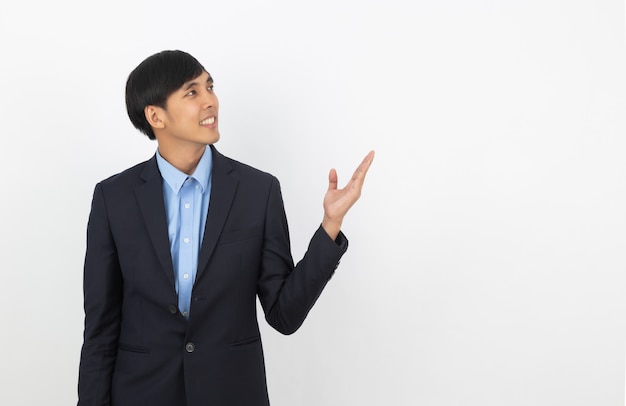 Young asian business man pointing to the side with a hand to present a product or an idea while looking forward