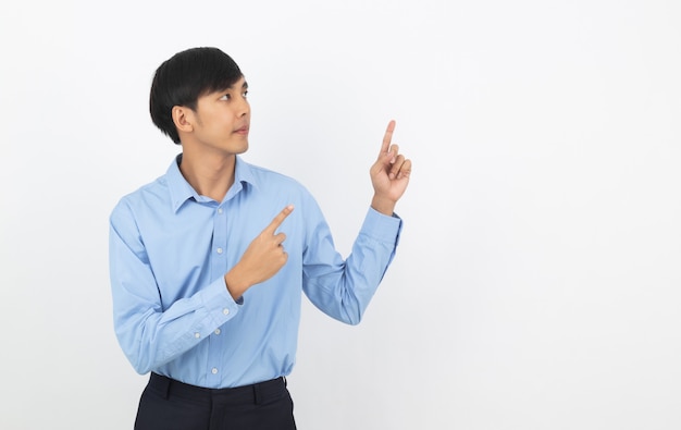 Young asian business man with blue shirt pointing to the side with a hand to present a product or an idea isolated on white background.